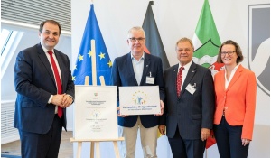 Nathanael Liminski (l.) und Ina Scharrenbach überreichen die Urkunde an Friedhelm Pausen und Peter-Olaf Hoffmann (2. v. r.)